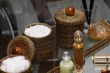 Decorative items including woven containers, a bottle, and a crystal on a reflective surface.
