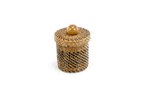 Decorative woven container with a wooden bead on a white background