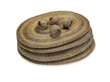 Set of woven oval placemats and napkin rings on a white background