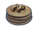 Stack of woven placemats with black beads on a white background