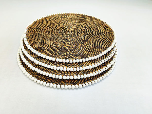 Set of round woven placemats with a white and brown color scheme on a light gray background.