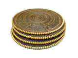 Stack of woven placemats with concentric circle pattern on a white background