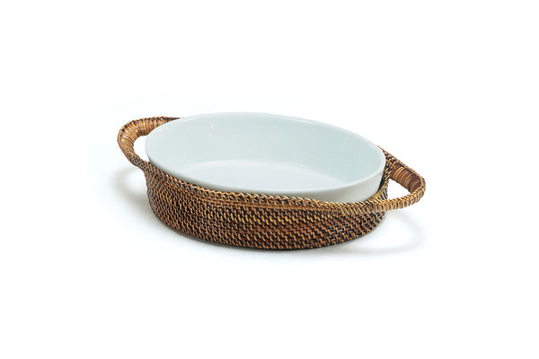 Calaisio handwoven oval basket with Pillivuyt 1-quart porcelain baker filled with food on a rustic dining table.